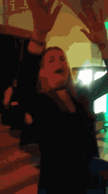 a blurry picture of a woman raising her arms in the air
