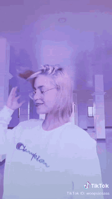 a woman wearing a white champion shirt is dancing
