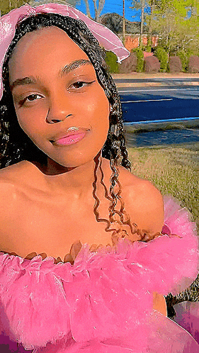 a young woman wearing a pink dress and a pink headband