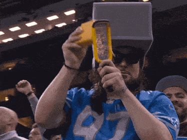 a man in a blue jersey with the number 40 on it is grating cheese