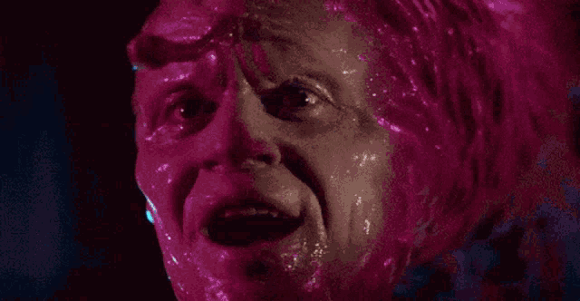 a close up of a person 's face covered in pink liquid