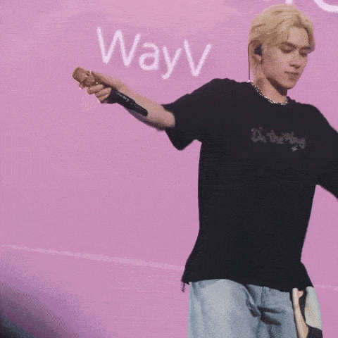 a person standing in front of a pink wall with the word way on it