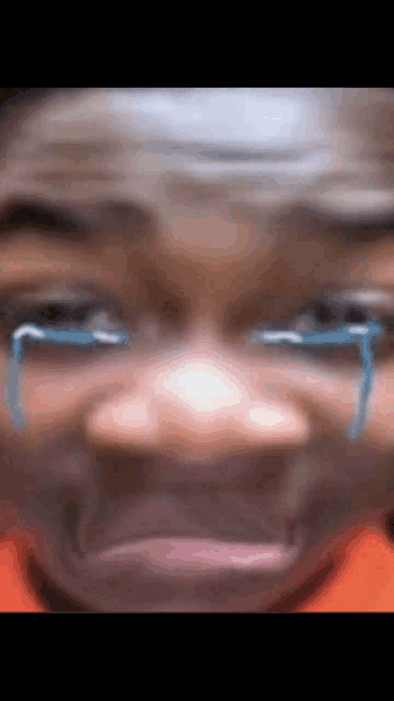 a close up of a person 's face with tears coming out of his eyes .