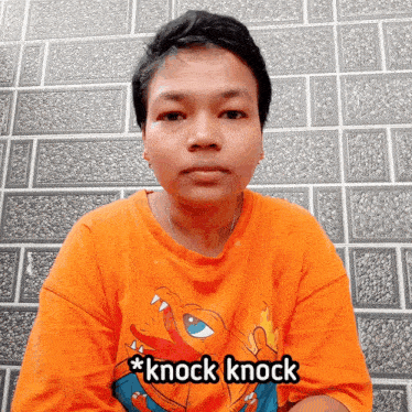 a person wearing an orange shirt that says * knock knock