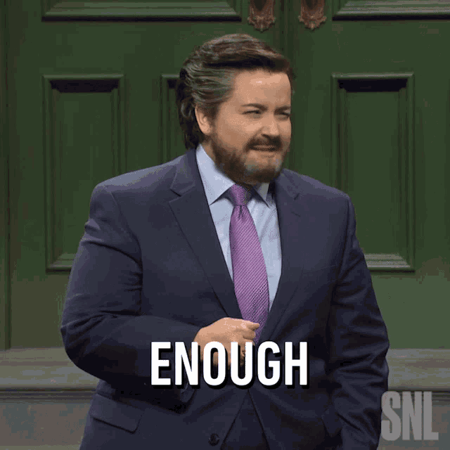 a man in a suit and tie has the word enough written on his chest