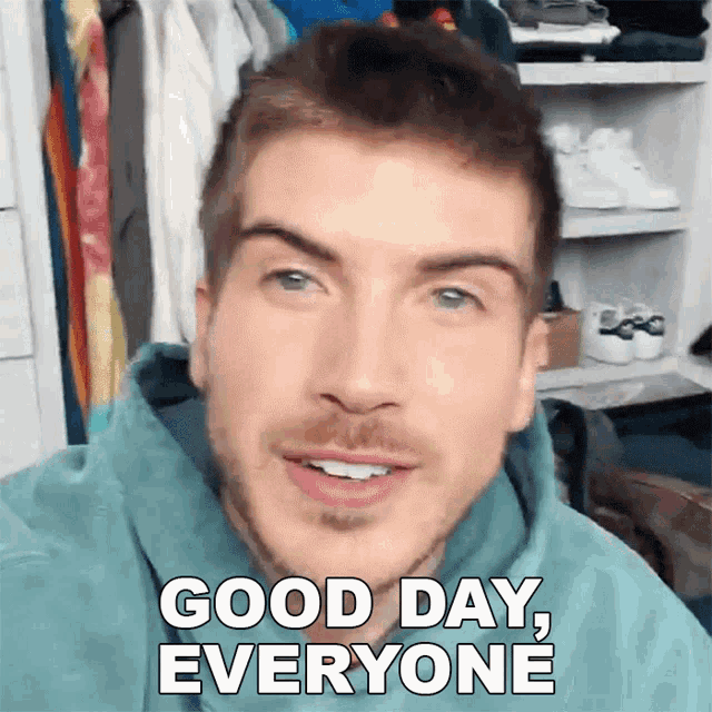 a man with a beard is smiling and says good day everyone