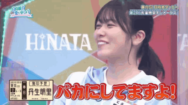 a girl is smiling in front of a sign that says hinata on it