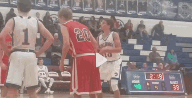 a basketball player wearing a number 20 jersey stands next to another player wearing a number 13 jersey