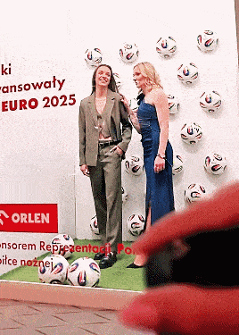 two women standing in front of a wall that says euro 2025 on it