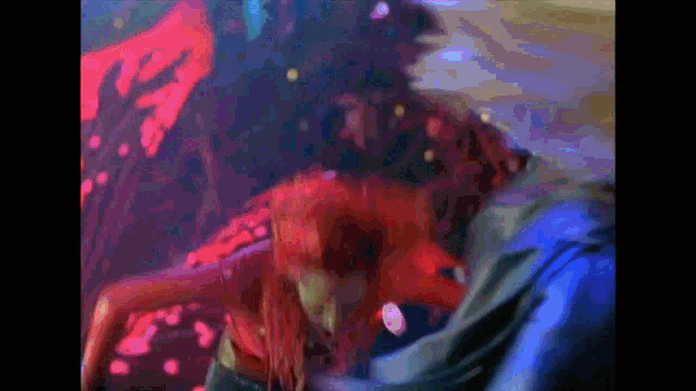 a woman with red hair is dancing with a man in a dark room