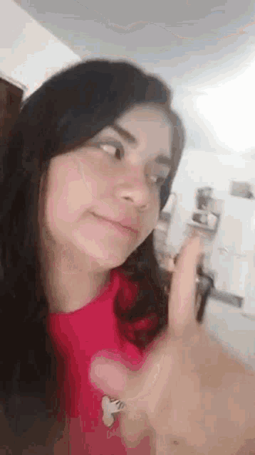 a young woman in a red shirt is giving a thumbs up sign .