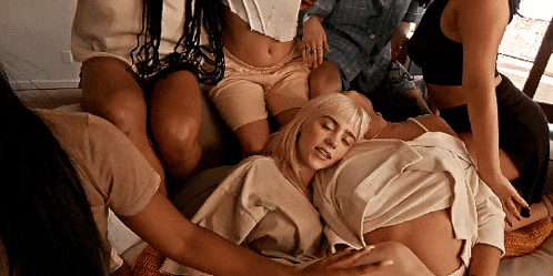 a group of women are sitting around a woman who is laying down