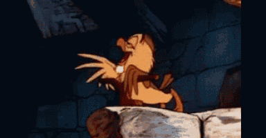a cartoon character with wings is standing on a rock in a dark room .