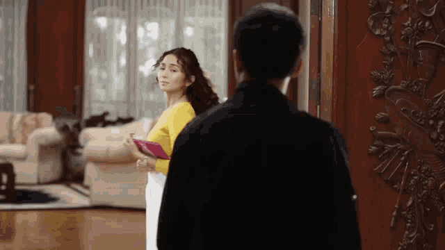 a man and a woman are standing in front of a door