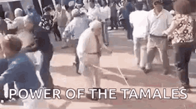 a group of people are dancing in a street in front of a crowd .