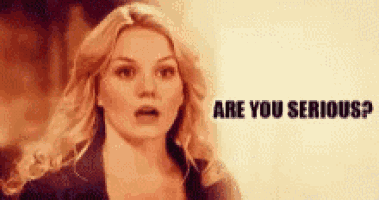 a woman is standing in front of a sign that says are you serious ?