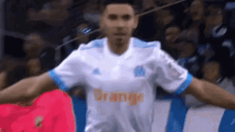 a soccer player wearing a white jersey with orange written on the front