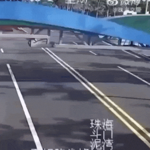a blue bridge over a road with chinese writing on the side