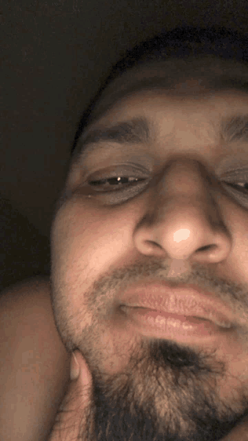 a close up of a man 's face with his hand on his chin
