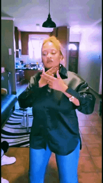 a woman in a black shirt is dancing in a kitchen