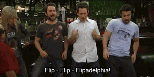 a group of men are dancing in a bar and one of them is wearing a shirt that says adelphia