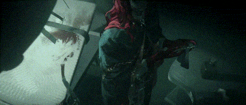 a person in a red hooded jacket is holding a sword