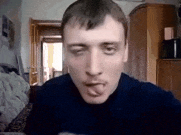 a man is sticking his tongue out while sitting on a couch .