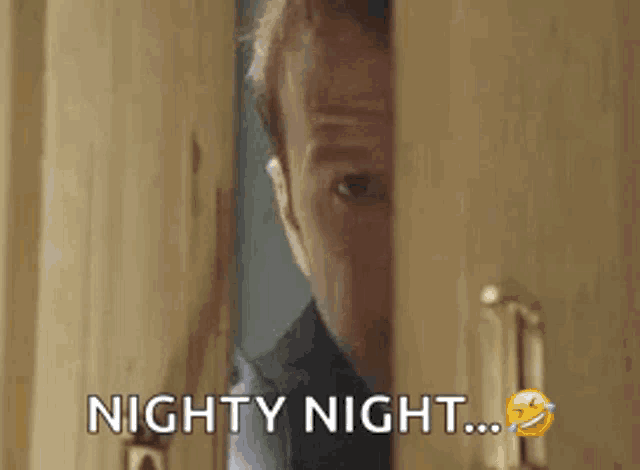 a man is peeking out of a door with the words `` nighty night '' written on it .