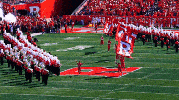 a marching band on a field with a flag that says ' uc ' on it
