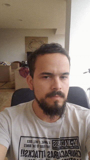 a man with a beard is wearing a t-shirt that says ' i2xjatti ' on the front