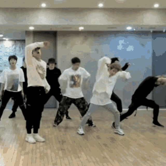 a group of people are dancing on a wooden floor in a room .