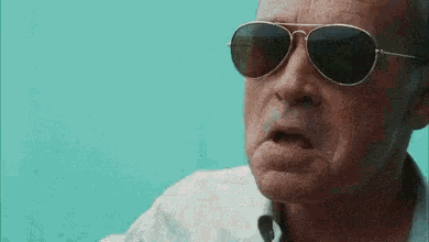 a close up of a man wearing sunglasses making a face