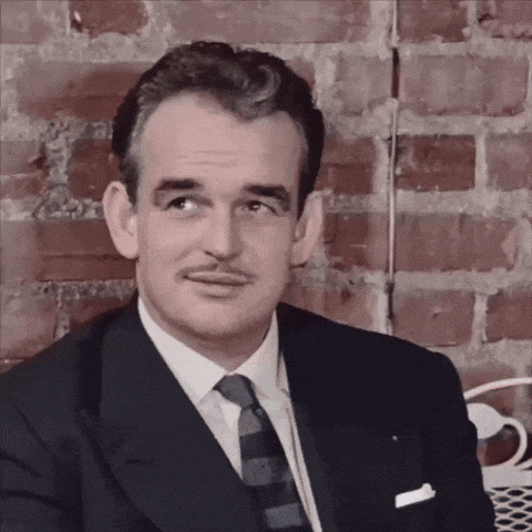 a man with a mustache wearing a suit and tie