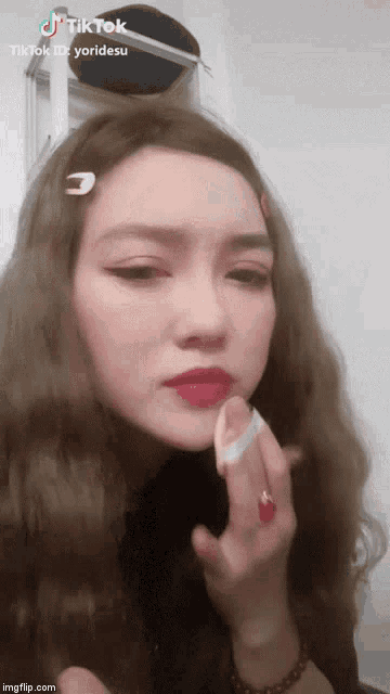 a tiktok video of a woman applying makeup to her face