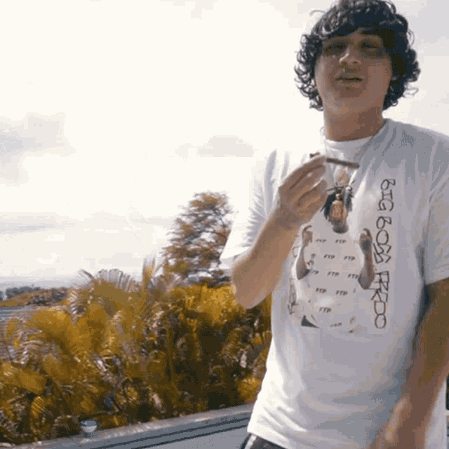a man wearing a t-shirt that says ftp is smoking a cigarette