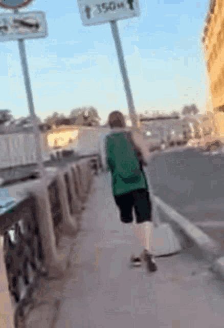 a person walking down a sidewalk with a sign that says 250 meters