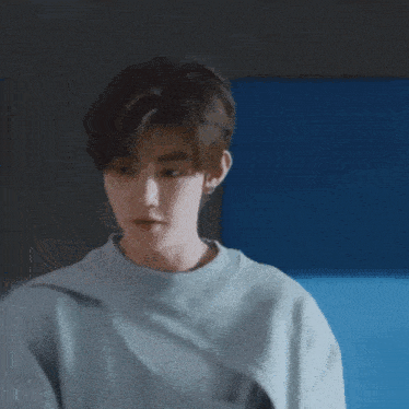 a young man in a grey nike sweatshirt is reaching out his hands