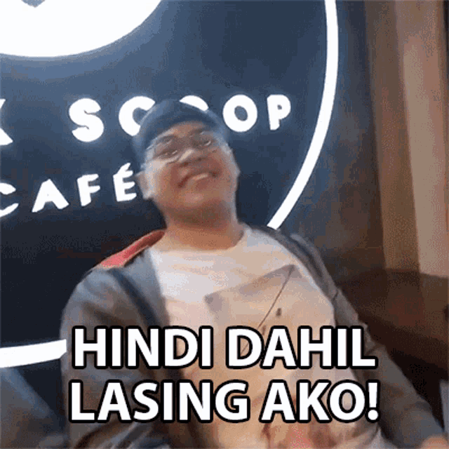 a man sitting in front of a scoop cafe sign