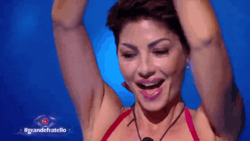 a woman in a red bikini is raising her arms in the air