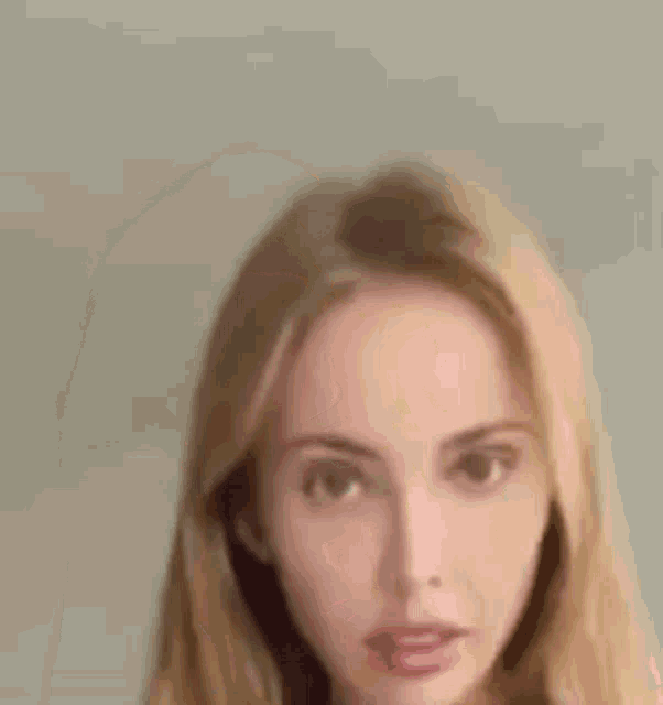 a close up of a woman 's face with long blonde hair .