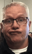 a man with glasses is making a funny face .