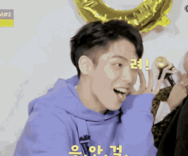 a man wearing a purple hoodie with a yellow balloon in the background