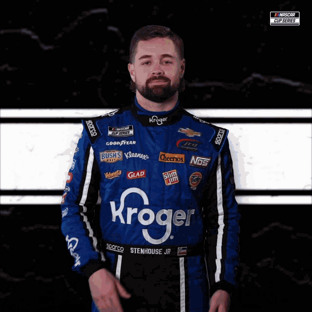 a man wearing a blue and black kroger racing suit