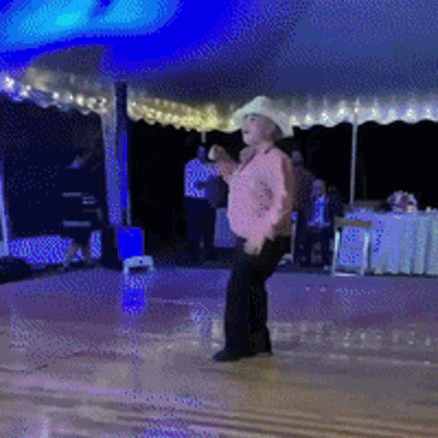 a man in a cowboy hat dancing on a dance floor