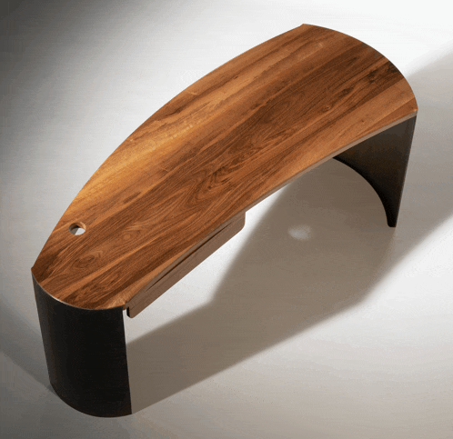 a curved wooden desk with a black base