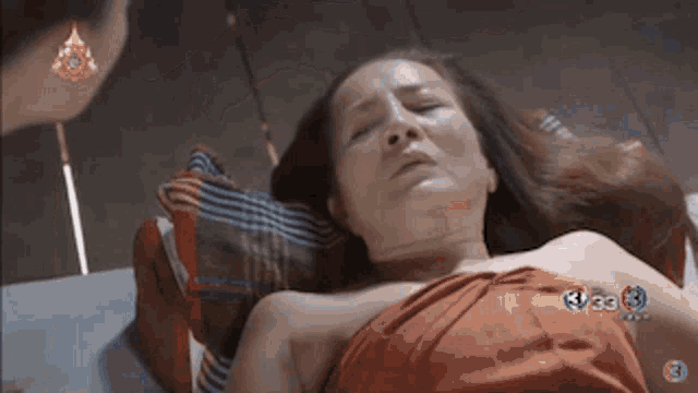 a woman is laying on a bed with the number 3 on the bottom right