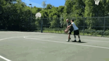 two people are playing basketball on a court