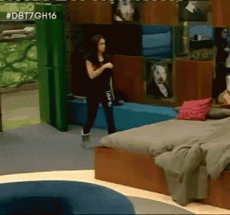 a woman is standing in a room with the number dbt7gh16 on the bottom