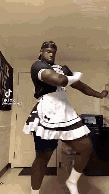 a man is dancing in a maid dress .