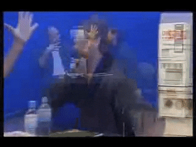 a blurry picture of a man standing in front of a refrigerator with a bottle of water in front of him